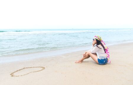 Fashion woman relax on the beach. White sand, blue cloudy sky and crystal sea of tropical beach.の写真素材