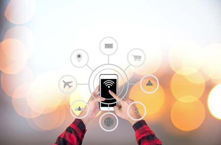 Businessman touching smart phone automation concept with icons showing the functionalities of this new technologyの写真素材