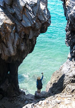 Travel women take a photo in a cave near the sea in Keo Sichang, Thailandの写真素材
