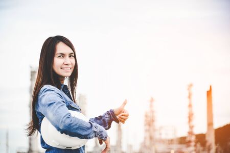 Engineer woman holding white helmet for workers security control at power plant energy industry. Engineer Conceptの写真素材