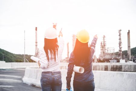 Engineers woman holding blueprint with radio for workers security control at power plant energy industry. Engineer Conceptの写真素材