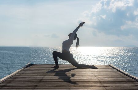 Healthy woman lifestyle exercising vital meditate and  practicing yoga at seashore, nature background.  Healthy Concept.の写真素材