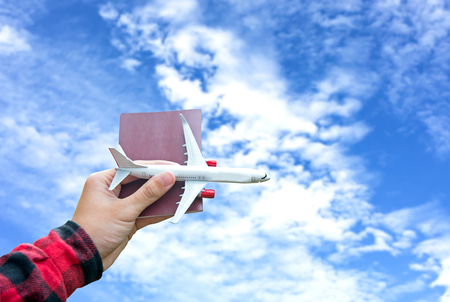 Tourist holding airplane  flight travel and passport traveller fly travelling citizenship air on blue sky background.  Travel Concept.の写真素材