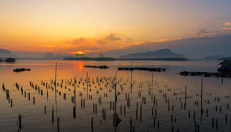 Beautiful sunrise landscape view of fisherman and wooden boat in early morming at Samchong-tai fishing village in Phang-Nga,Thailandの写真素材