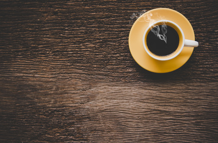 A yellow cup of coffee on old wooden table. Lifestyle Conceptの写真素材