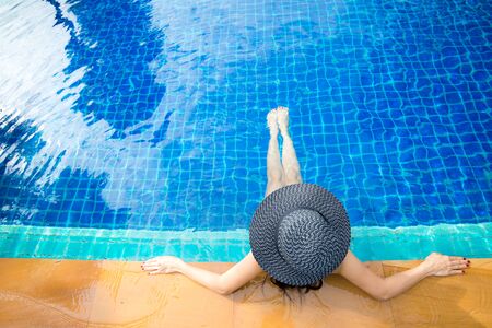 Women lifestyle relaxing near luxury swimming pool sunbath, summer day at the beach resort in the hotel. Summer Conceptの写真素材