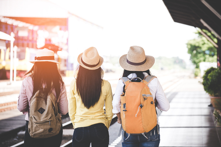 Group of asia women traveler and tourist  traveling backpack holding map and waiting in a train station platform.  Travel Concept.の写真素材
