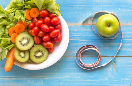 Healthy lifestyle for women diet with measuring tape, vegetable fresh, green apples blue on wooden.  Healthy Concept.の写真素材
