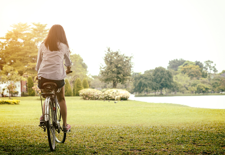Woman riding a bicycle in a park outdoor at summer day. Active people. Lifestye Concept.  Vintage Toneの写真素材