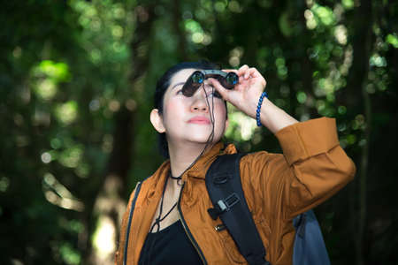 Tourist travel woman look binoculars on the in the forest.  Travel Concept.の写真素材