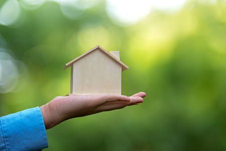 Man holding house representing home ownership and saving money the Real Estate business.の写真素材