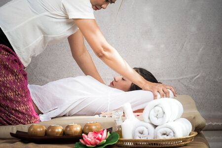 Thai Masseuse doing massage for woman in spa salon. Asian beautiful woman getting thai herbal massage compress massage in spa.She is very relaxed.  Healthy Conceptの写真素材