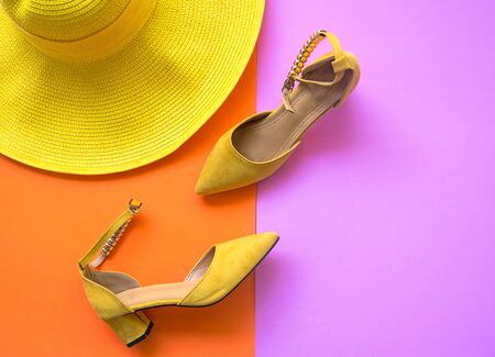 Fashion woman accessories set. Trendy fashion yellow shoes heels, stylish big hat. Colorfull orange and pink background.  Lifestyle Concept.の写真素材