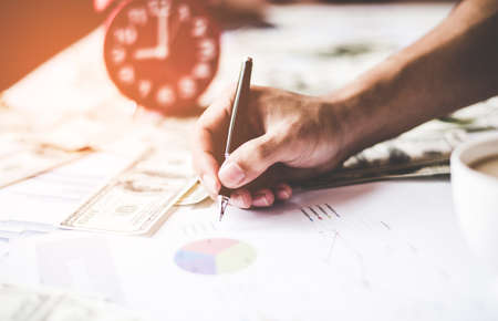 Business concept with money and documents graph, report finance, businessman writing graph.  Business Concept. select focusの写真素材
