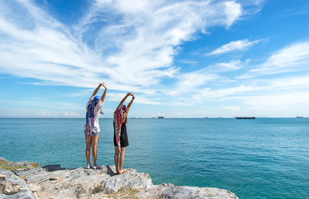 Two traveler young women seeing the beautiful beach and blue sky, so happy and relax.  Travel Concept.の写真素材
