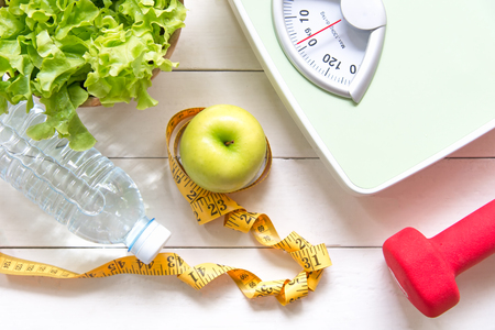 Green apple and Weight scale,measure tap with fresh vegetable, clean water and sport equipment for women diet slimming.  Diet and Healthy Conceptの写真素材