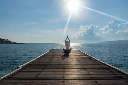 Healthy woman lifestyle exercising vital meditate and  practicing yoga at on the bridge seashore, nature background.  Healthy Concept.の写真素材