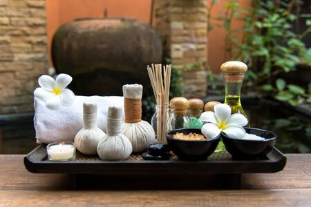 Thai spa composition treatments aroma therapy with candles and Plumeria flowers on wooden table close up.  Healthy Concept.の写真素材