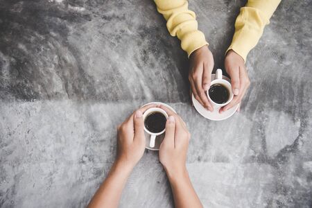 Top view with copy space.  Couple in love holding hands with coffee love on  table, vintage tone. Lifestyle Conceptの写真素材