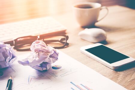 Business workplace with keyboard mouse and crumpled paper balls ,papers with graphs and diagrams for investment.  Business  and Investment Conceptの写真素材