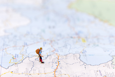 Miniature traveler with backpack standing on wold map for travel around the world.  Travel Conceptの写真素材