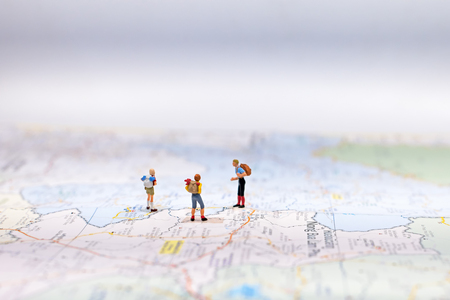 Miniature Group traveler with backpack standing on wold map for travel around the world.  Travel Concept, select focusの写真素材