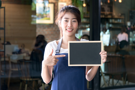 Barista asian women holding label Coffee order in the coffee shop. Service Conceptの写真素材