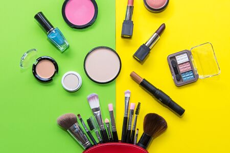Makeup cosmetics tools background and beauty cosmetics, products and facial cosmetics package lipstick, eyeshadow on the  green and yellow background.  Lifestyle Concept.の写真素材