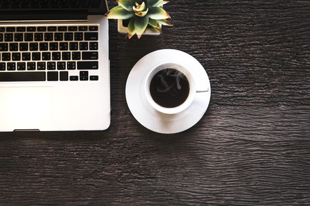Cup of coffee with work in the laptop,morning on old wooden table. Lifestyle Conceptの写真素材