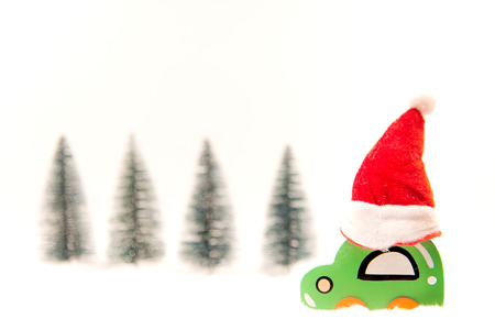 Christmas red jat on wood toy car on the snow. Christmas holiday celebration conceptの写真素材