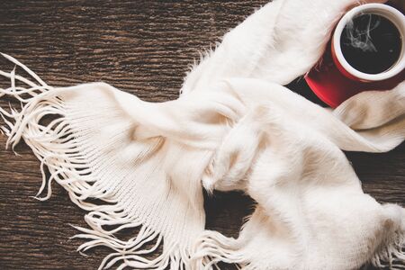 Cozy winter background, cup of hot coffee with marshmallow, warm knitted sweater on old wooden...