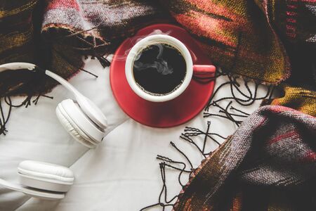Cozy winter home background, cup of hot coffee with marshmallow, warm knitted sweater on white bed background, vintage tone.  Lifestyle conceptの写真素材