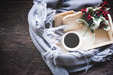 Cup of coffee on rustic wooden serving tray in the cozy winter with blanket. Knitting warm woolen sweater in the winter weekend, top view. Lifestyle Concept.の写真素材