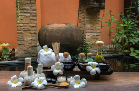 Thai spa composition treatments aroma therapy with candles and Plumeria flowers on wooden table close up.  Healthy Concept.の写真素材