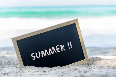 Closeup of a chalkboard with the text summer written on the sand of a beach.  Summer Conceptの写真素材