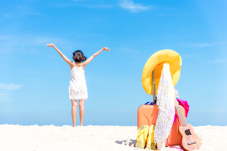 Summer traveling with ukulele and Fashion woman swimsuit Bikini, fish star, sun glasses, camera and hat on the sand beach in the holiday, blurry freedom and lifestyle woman background.の写真素材