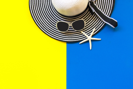 Summer Fashion woman big hat and sunglasses go to travel in the beach. Tropical sea. Unusual top view, yellow and blue background. Summer Concept.の写真素材