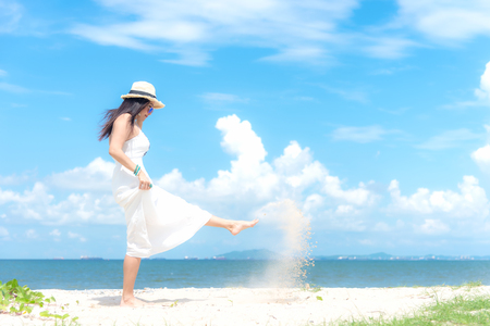 Smiling asian woman white wearing fashion summer walking on the sandy ocean beach.  Woman enjoy and relax vacation. Lifestyle and Travel Conceptの写真素材