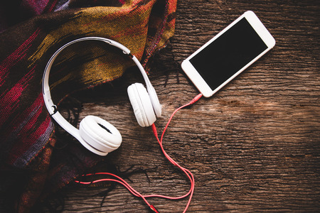 Cozy winter background, cup of hot coffee with marshmallow and headphone music, warm knitted sweater, vintage tone. Lifestyle and music conceptの写真素材