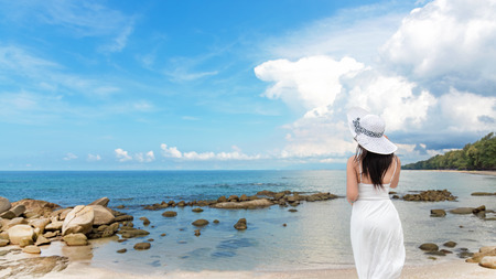 Summer Day. Lifestyle  woman wearing white dress fashion summer beach  on the sandy ocean beach. Happy woman enjoy and relax vacation and holiday. Travel Concept.の写真素材