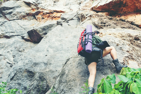 Hiker woman climb up the last section in mountains. Traveler walking in outdoor lifestyle adventure and camping. Travel Concept.の写真素材