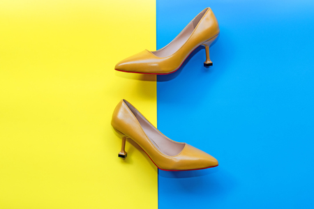 Fashion woman accessories set. Trendy yellow fashion shoes heels. blue and yellow pastel color background. Fashion Concept.の写真素材