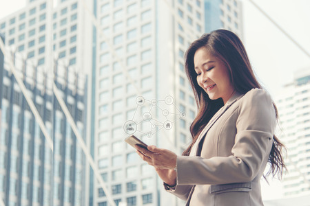 Business women using social network connection modern city background.  Technology and Business Conceptの写真素材