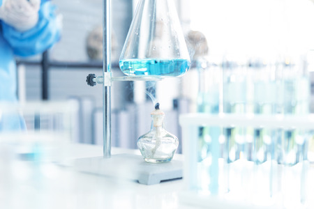Scientists analyzing study data and evaluating microscope.  Health care researchers doing some research with dropper chemical testing and working in life science laboratory.の写真素材