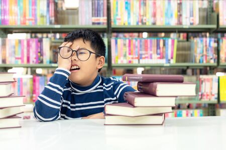 Kids asia boy reading books for education and go to school in library . Education and Lifestyle Conceptの写真素材