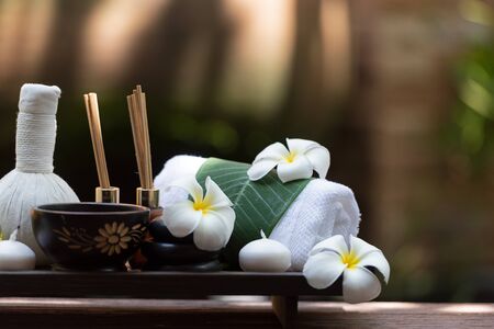 Thai spa composition treatments aroma therapy with candles and Plumeria flowers on wooden table close up. Healthy and Relax Conceptの写真素材
