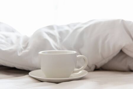 Fresh morning coffee on the white bed in the sunny day.  Lifestyle Conceptの写真素材