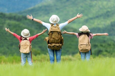 Group asian family children raise arms and standing see the outdoors, adventure and tourism for destination and leisure trips with mountain for education and relax in nature park.Â  Travel vacations and Life Conceptの写真素材