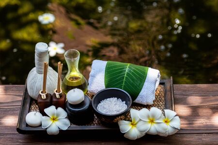 Thai spa composition treatments aroma therapy with candles and Plumeria flowers on wooden table close up. Healthy and Relax Conceptの写真素材
