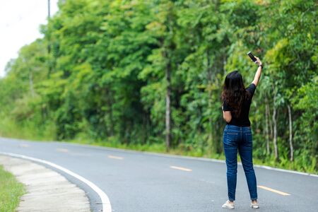 Traveler or tourism Asian women selfie mobile in the nature park, vacations time.  People smiling freedom and relax on the road nature. . Lifestyle Conceptの写真素材